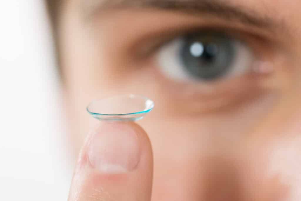 A woman holding a contact lens