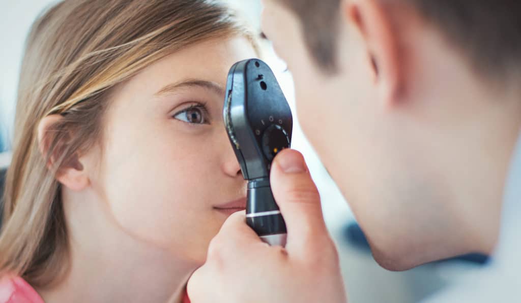 Doctor looking into female patients eye for exam
